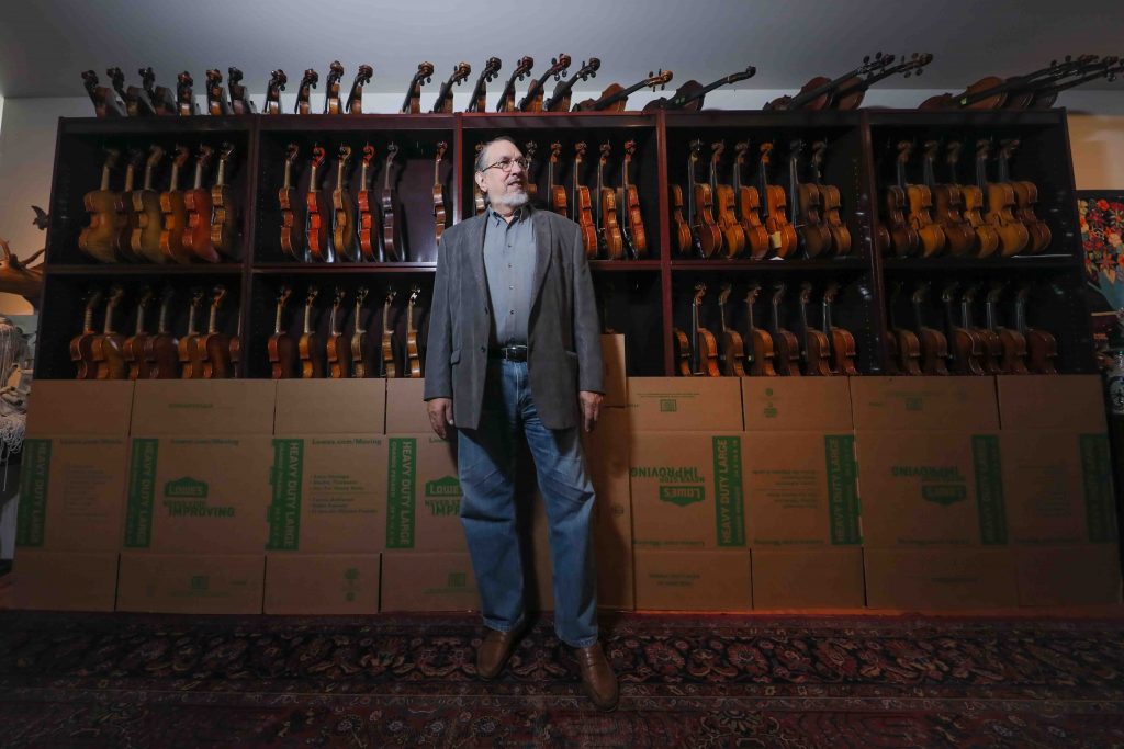 NEWS 2019 JULY 16 – David Bromberg violin collection Singer-songwriter and session musician David Bromberg stands in front of a portion of his collection of violins. (Saquan Stimpson for WHYY)