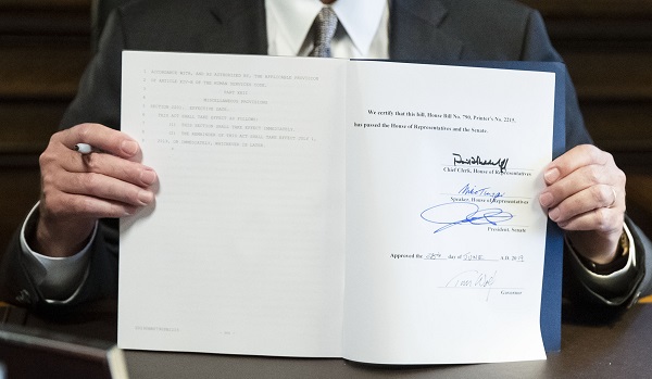 Governor Tom Wolf holding up the signed 2019-20 budget. The Commonwealth Foundation says it contains $61 million in earmarks. (Matt Rourke/AP Photo)