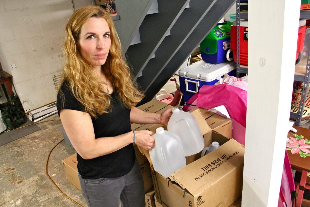 2019 05 17-e lee-jessica cutaiar-sellersville-pfas contamination well water Jessica Cutaiar grabs a couple gallons of water from her basement of her Sellersville home. Her well water is undrinkable, contaminated with PFAs. (Emma Lee/WHYY)