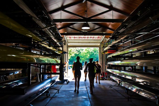 Girls 19 years and under walk through a boathouse during the Mid-Atlantic U.S. Olympic Development Program program on the Schuylkill in Philadelphia. (Kimberly Paynter/WHYY)