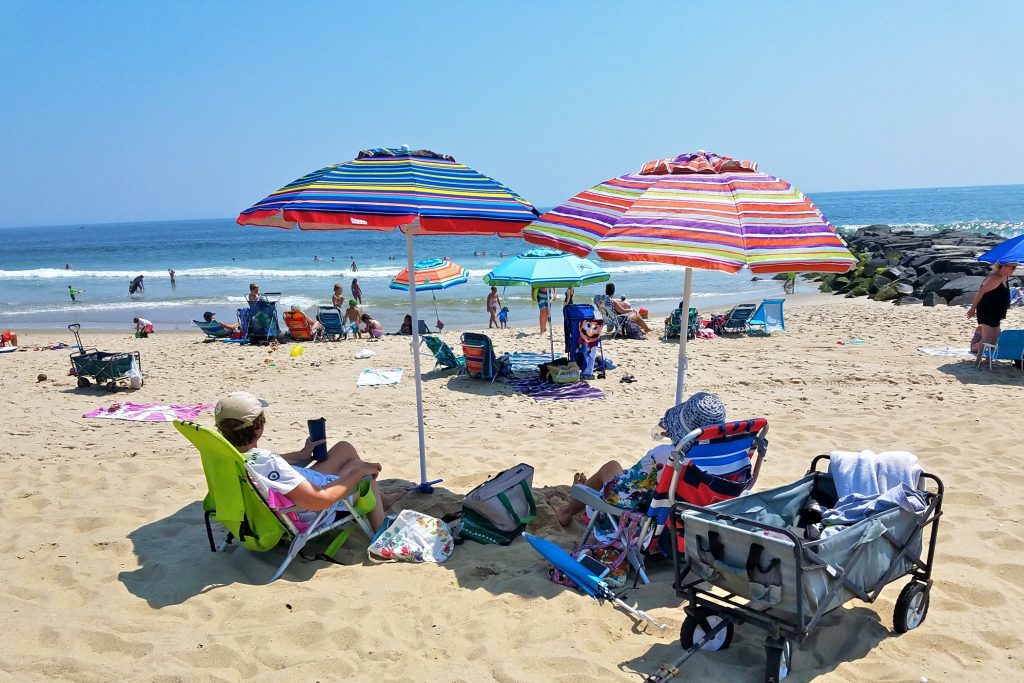 2019 07 29-n pugliese-manasquan beach-umbrella safety Beverly Jaker of Woodbridge (right) and her sister, Marilyn, lounge under beach umbrellas in Manasquan on July 29, 2019. (Nicholas Pugliese/WHYY)