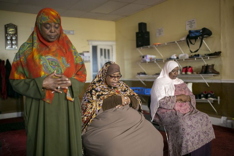 Stephanie Adams (left) prays during a Millati Islami meeting in Camden, N.J. (Miguel Martinez for WHYY)