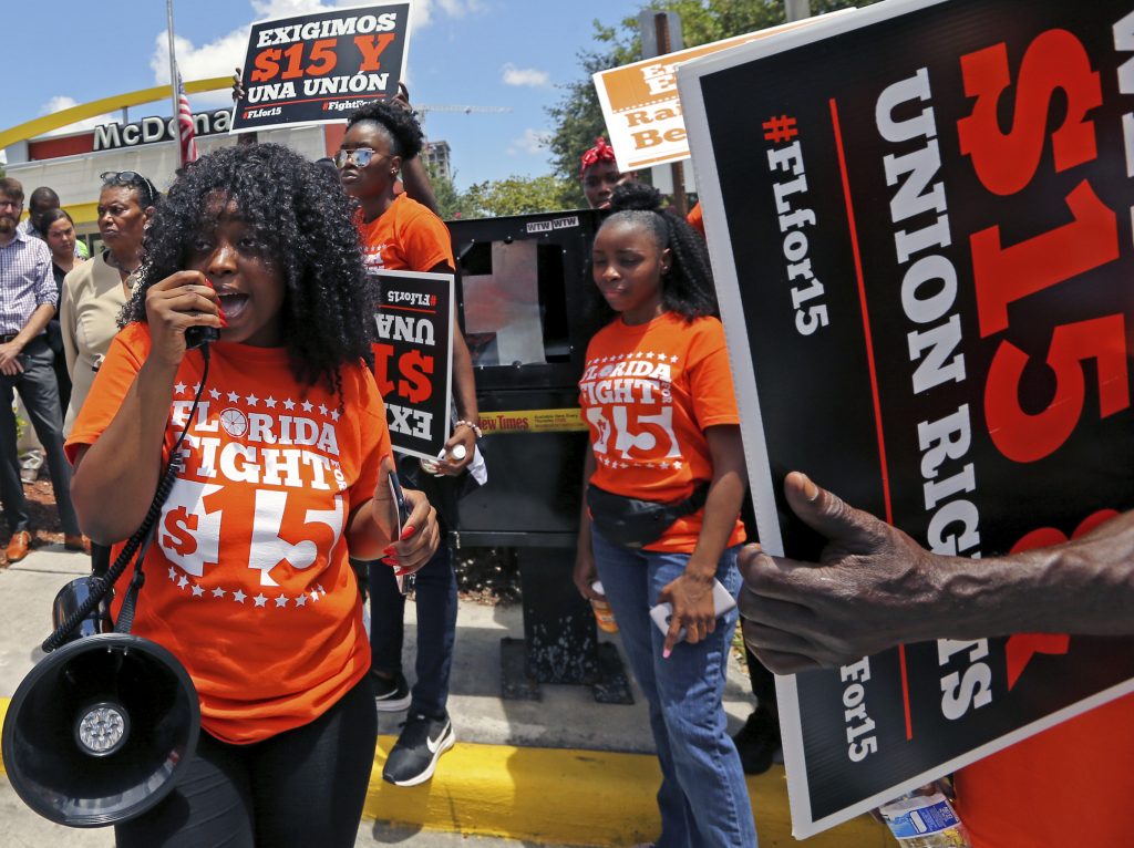 Minimum Wage Strike Noji Olaigbe, left, from the Fight for a $15 Minimum Wage movement speaks during a McDonald's workers strike as part of the nationwide movement, at the McDonald's at 27 West Broward Blvd. in Fort Lauderdale, Fla. on Thursday, May 23, 2019. (David Santiago/Miami Herald via AP)