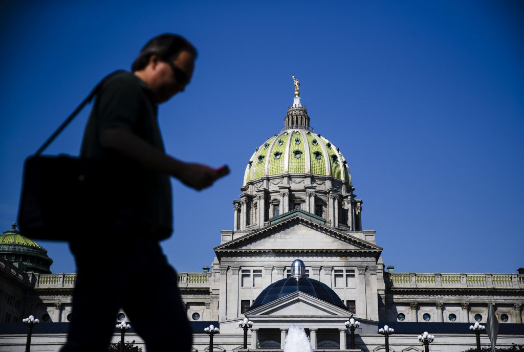 Pennsylvania Budget A pedestrian walks by the state Capitol in Harrisburg, Pa., Friday, June 28, 2019. (AP Photo/Matt Rourke)