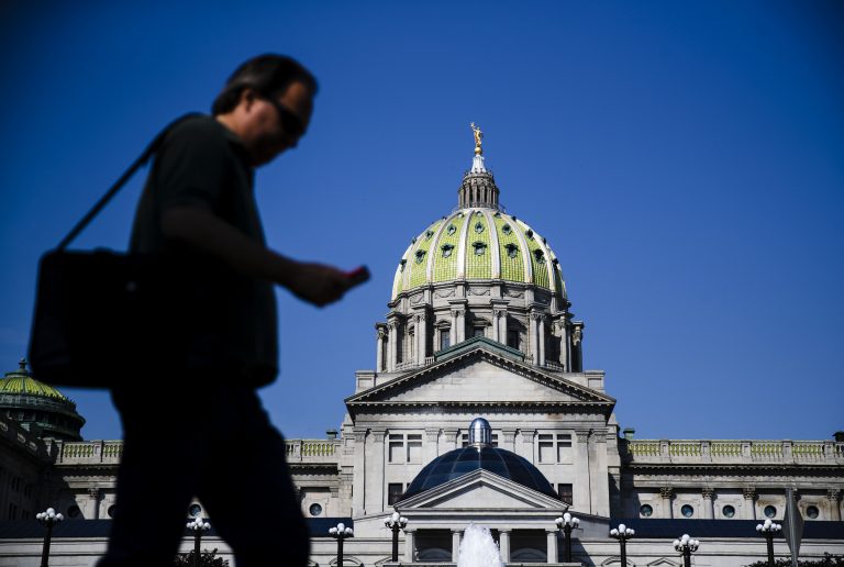 A pedestrian walks by the state Capitol in Harrisburg, Pa., Friday, June 28, 2019.  (AP Photo/Matt Rourke)