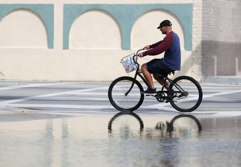 Sunny-Day Flooding In this Oct. 9, 2018, file photo, a cyclist rides past an area flooded during a King Tide, an especially high tide, in Miami. Federal scientists, according to a report released Wednesday, July 10, 2019, predict 40 places in the U.S. will experience higher than normal rates of so-called sunny day flooding this year due to rising sea levels and an abnormal El Nino weather system. (Wilfredo Lee/AP Photo, FIle)