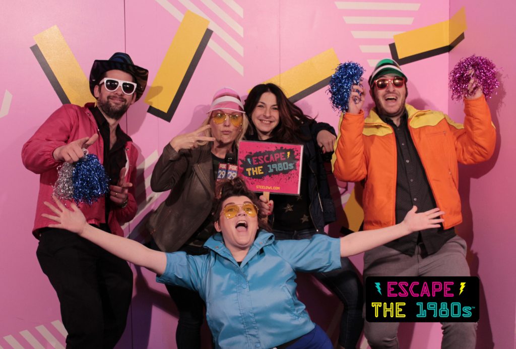 ESCAPE_the_80s Employees at Escape the 1980s (from left to right): John Foster, Jennaphr Frederick, Elisabeth Garson, Nick Einstman, and Krystle Ann Griffin in the game room's photo booth. (Image courtesy of Escape the 1980s)