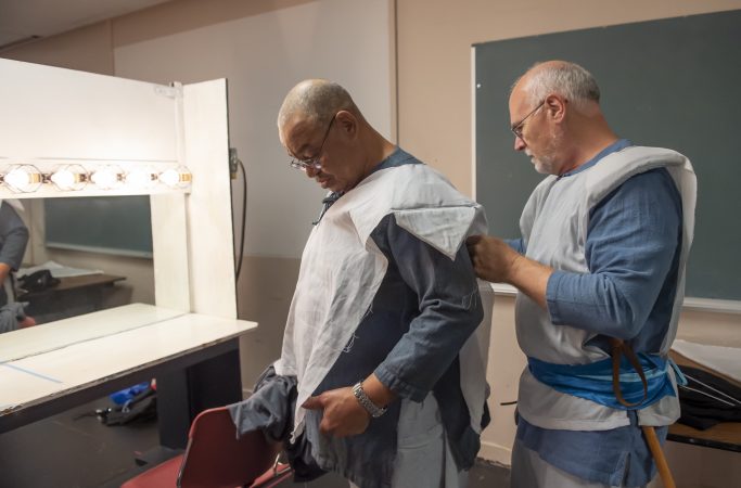 Sheldon Rich assists Floyd Crump Jr. with his costume. (Jonathan Wilson for WHYY)