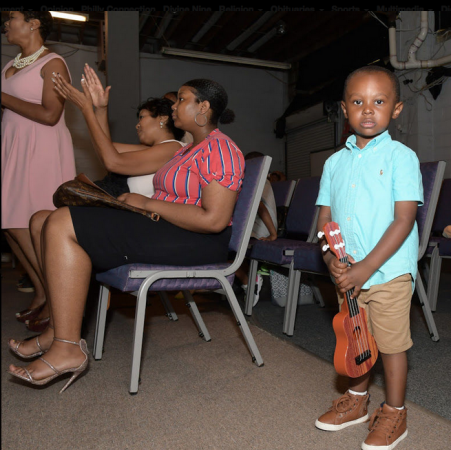 Three-year-old Carter of Truth Church Worship Center holds his guitar during service (Marissa Weekes Mason/The Philadelphia Tribune)