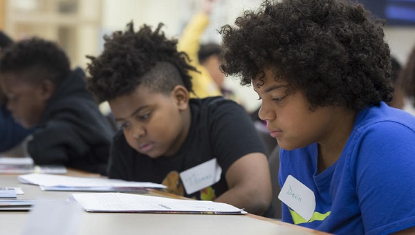 Woodland Hills Intermediate School Fifth-graders Thomas Medley, (left), and Devin Walker study their training materials as they learn to become student leaders at Woodland Hills Intermediate in 2017. (The University of Pittsburgh)