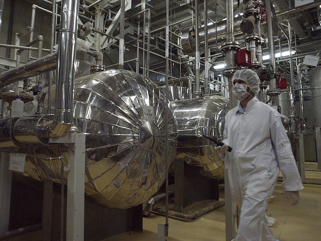 An Iranian security official in protective clothing walks through a uranium conversion facility in 2005. Iran says it is now enriching uranium above the limit set in the 2015 nuclear deal. An Iranian security official in protective clothing walks through a uranium conversion facility in 2005. Iran says it is now enriching uranium above the limit set in the 2015 nuclear deal. (Vahid Salemi/AP Photo)