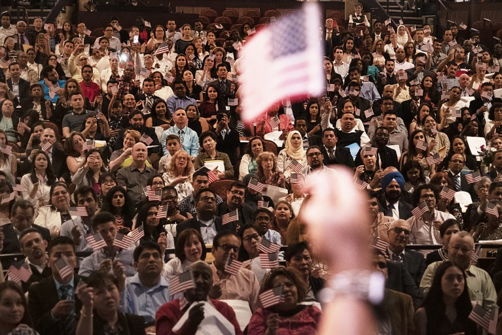 A naturalization ceremony of new U.S. citizens at the Hylton Performing Arts Center in Manassas, Virginia. The U.S. citizenship oath today is 140 words. It wasn’t until 1929 that the oath’s text was standardized, and the oath was amended in 1952 to emphasize service to country as the U.S. faced a growing threat from the Soviet Union. A naturalization ceremony of new U.S. citizens at the Hylton Performing Arts Center in Manassas, Virginia. The U.S. citizenship oath today is 140 words. It wasn't until 1929 that the oath's text was standardized, and the oath was amended in 1952 to emphasize service to country as the U.S. faced a growing threat from the Soviet Union. (Shuran Huang/NPR)