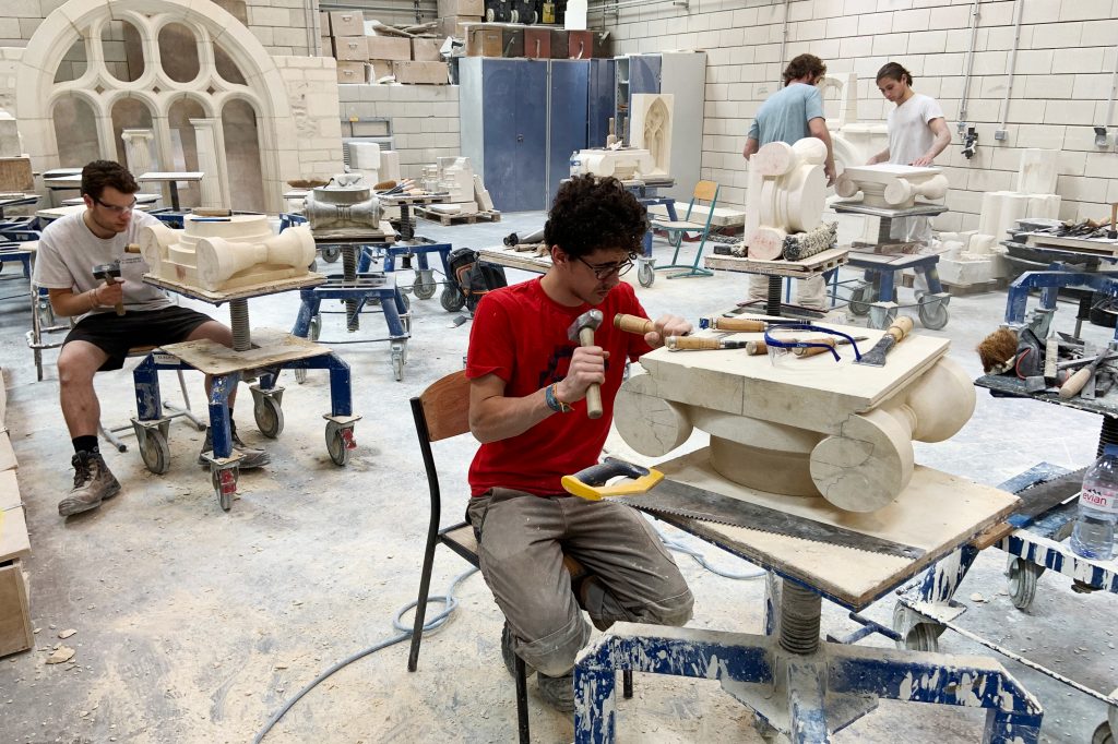 Students chip and chisel away at heavy slabs of stone in the workshops of the Hector Guimard high school, less than three miles from Paris’ Notre Dame cathedral. Students chip and chisel away at heavy slabs of stone in the workshops of the Hector Guimard high school, less than three miles from Paris' Notre Dame cathedral. (Eleanor Beardsley/NPR)
