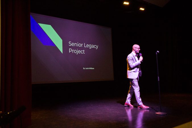 Senior cohort advisor Stephen Schaeffer introduces students for the legacy project presentations. (Kimberly Paynter/Keystone Crossroads)