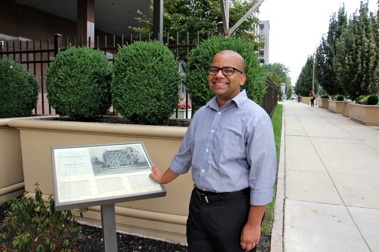 Samip Mallik, director and co-founder of the South Asian American Digital Archive, stands at 6th and Arch streets, the former site of the Female Medical College of Pennsylvania. (Emma Lee/WHYY)