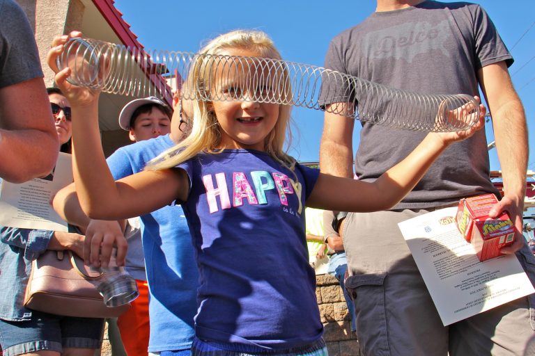 Maura McGlensey, 6, of Clifton Heights, plays with a Slinky during the dedication ceremony of a historical marker commemorating the manufacture of the popular toy at James Industries in Clifton Heights. (Emma Lee/WHYY)