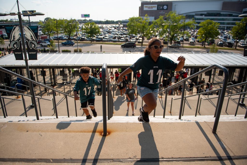 20190804_WHYY_Eagles Practice_D750_014 (1) Isaac and Jazzy Dyer, from Harrisburg, Pa., run up the steps to Lincoln Financial Field before the start of open practice on Sunday, August 4, 2019. (Kriston Jae Bethel for WHYY)