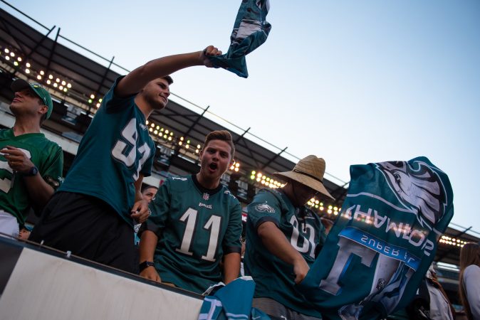 Ethan Minshall, Noah Carter and Nik Boone cheer along to the Eagle's fight song during open practice at Lincoln Financial Field on Sunday, August 4, 2019. (Kriston Jae Bethel for WHYY)