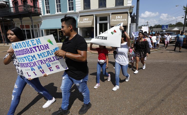 In this Aug. 11, 2019 photo, children of mainly Latino immigrant parents hold signs in support of them and those individuals picked up during an immigration raid at a food processing plant in Canton, Miss., following a Spanish Mass at Sacred Heart Catholic Church in Canton, Miss. Trump administration rules that could deny green cards to immigrants if they use Medicaid, food stamps, housing vouchers or other forms of public assistance are going into effect. (Rogelio V. Solis./AP Photo)