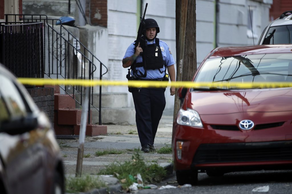 Gunman Firing at Police A police officer patrols the block near a house as they investigate an active shooting situation, Wednesday, Aug. 14, 2019, in the Nicetown neighborhood of Philadelphia. (AP Photo/Matt Rourke)