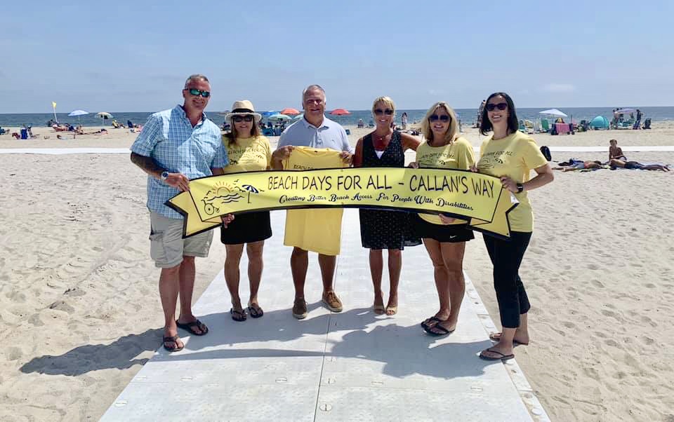IMG-9042 Beach Days for All founders Chris Aldrich (far left) and Jessica Miscio (second from right) stand with supporters Friday at the newly handicapped-accessible Maryland Avenue beach in Point Pleasant Beach. (Courtesy of Beach Days for All)