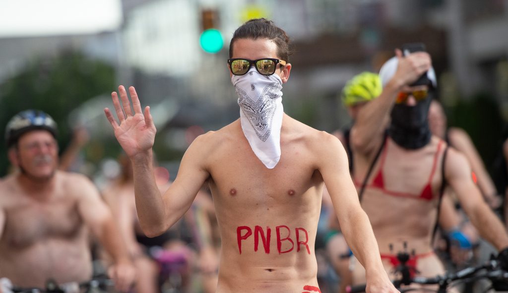 NAKED BIKE RACE 2019 8 A rider waves to approving pedestrians who stopped to watch the Philly Naked Bike Ride make its way through Center City. (Jonathan Wilson for WHYY)