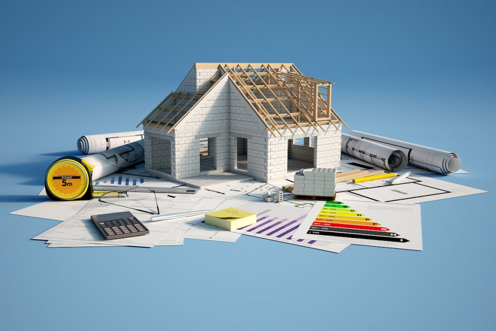 3D renderin of a house under construction on top of blueprints, mortgage forms and a energy efficien Bigstock/Franck Boston