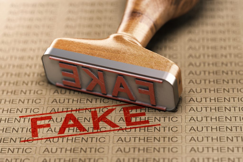 Rubber Stamp And Word Fake Printed On A Paper Background With The Repeated Text Authentic. Concept O Fake vs. Real