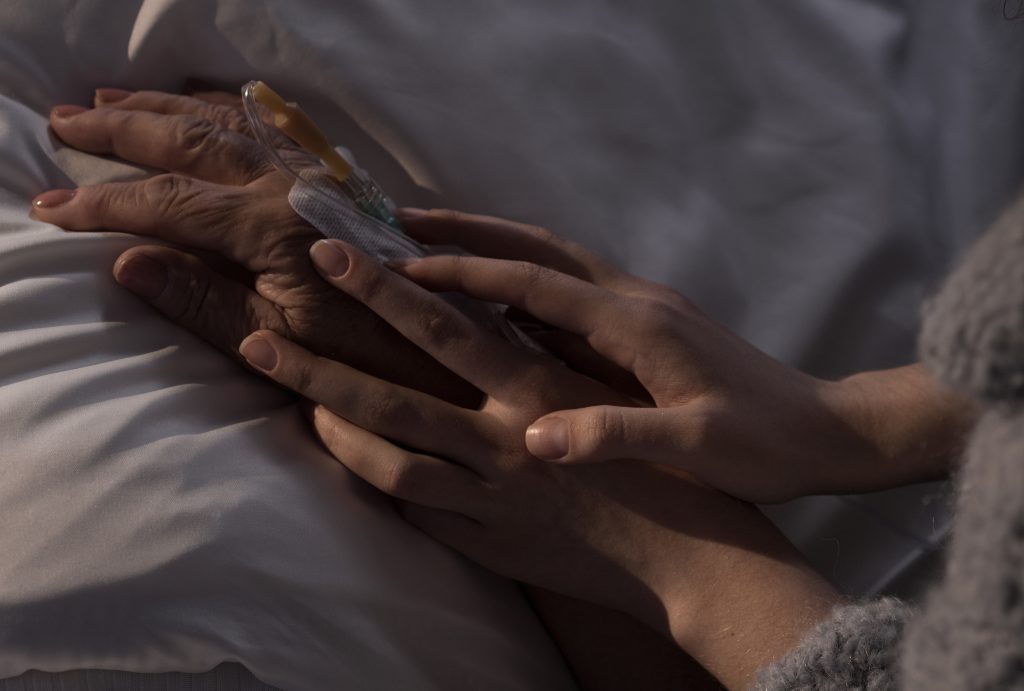 Woman Holding Ill Mother Hand Photo of woman holding terminally ill mother hand