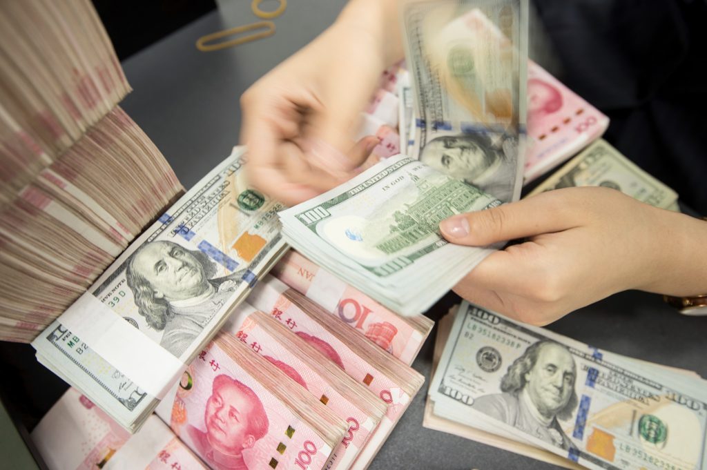 A Chinese bank employee counts 100-yuan notes and dollar bills at a counter in Nantong, in China’s eastern Jiangsu province, on Tuesday. A Chinese bank employee counts 100-yuan notes and dollar bills at a counter in Nantong, in China's eastern Jiangsu province, on Tuesday. (AFP/Getty Images)