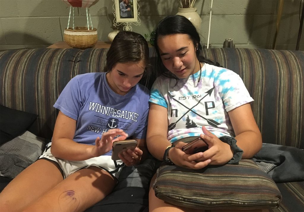 teensonphonesx2000 Kim Delea (left) and Alyssa Carroll, eyes on their smartphones.
(Daisy James for WHYY)