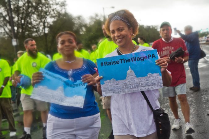 Two marchers call for higher wages at the Philadelphia Labor Day Parade. (Kimberly Paynter/WHYY)