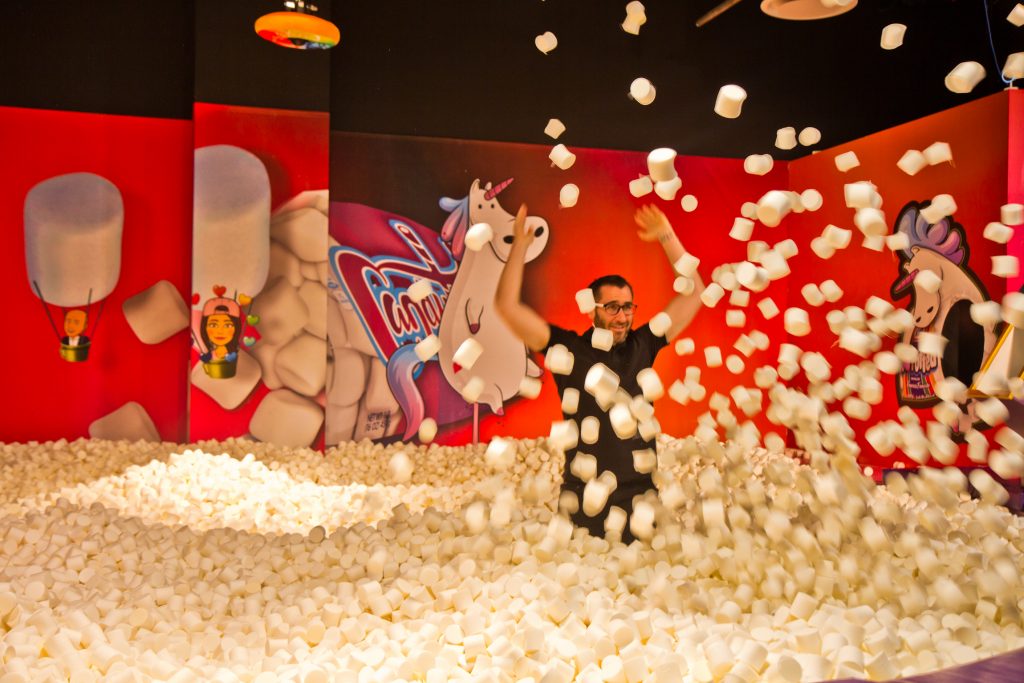 2019 09 17 kpaynter fashion district-8 copy Adults play in the 'highly instagrammable' marshmallow pit at the Fashion District's Candytopia exhibit. (Kimberly Paynter/WHYY)