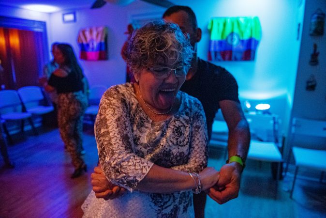 Milena Sanchez dances with her son, Einar Victoria, in a living room viejoteca on Saturday, September 14, 2019. (Kriston Jae Bethel for WHYY)