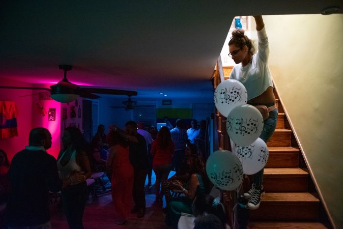 Kimberly Colon looks over the viejoteca dance scene hosted at her mother's home in Oxford Circle on Sunday, September 15, 2019. (Kriston Jae Bethel for WHYY)