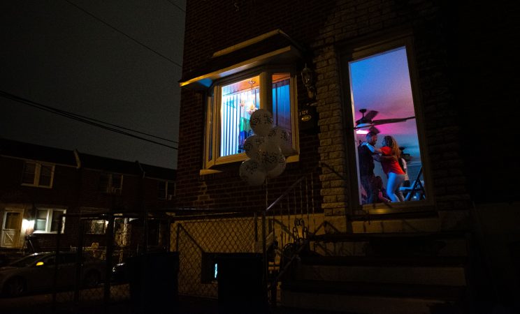 Einar Victoria is seen dancing with Liliana Acero through the front entrance of an Oxford Circle home-turned-viejoteca on Sunday, September 15, 2019. (Kriston Jae Bethel for WHYY)