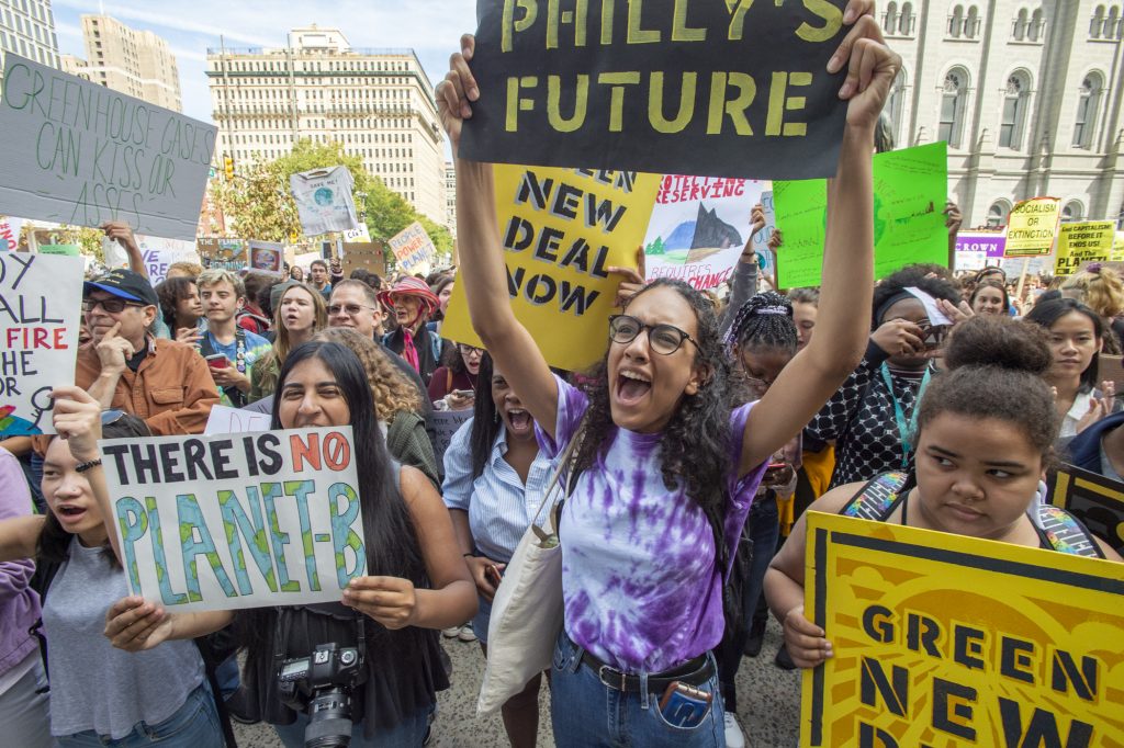 Climate-3 Masterman High School seniors Iman Acharya and Alina Kilcullen cheer for speakers at Philadelphia's climate strike on Sept. 20, 2019. (Jonathan Wilson for WHYY)