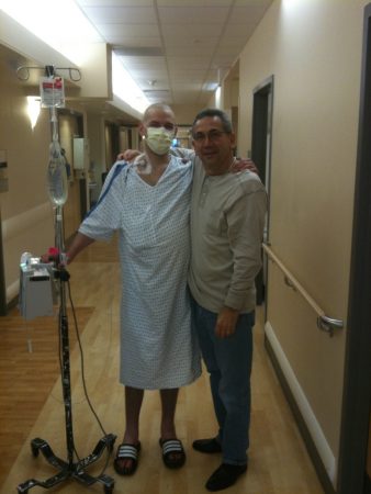 David with his Dad in the hospital. Courtesy of David Fajgenbaum