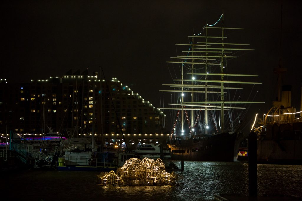 10 07 2019-e cohen – stephen talasnik installation – indpendence seaport museum-12 Stephen Talasnik's Endurance sits illuminated in the Delaware River boat basin ready for the opening of the FLOW exhibition. FLOW is a sculpture exhibit on the Delaware River in partnership with Philadelphia Sculptors and the Independence Seaport Museum. (Emily Cohen for WHYY)