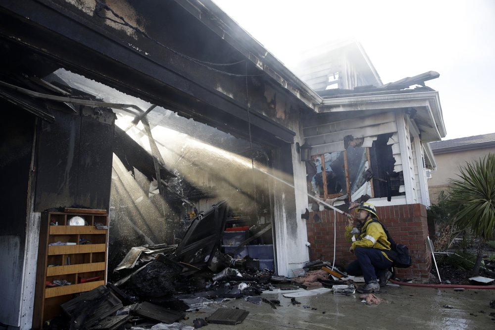 1000 Calib Willis of the Los Angeles County Fire Department hoses down a smoldering residence destroyed by a wildfire Friday, Oct. 25, 2019, in Santa Clarita, California. (Marcio Jose Sanchez/AP Photo)