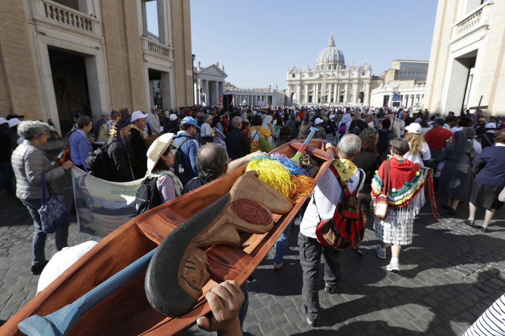 1000 (4) Saturday, Oct. 19, 2019, members of Amazon indigenous populations walk during a Via Crucis (Way of the Cross) procession from St. Angelo Castle to the Vatican. In foreground is a wooden statue portraying a naked pregnant woman. (Andrew Medichini/AP Photo)