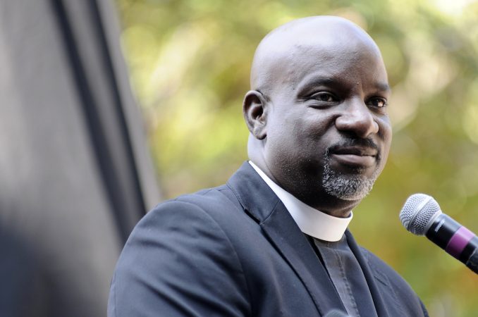Rev. Mark Tyler of Mother Bether A.M.E. Church speaks ahead of the unveiling of a state historical marker at the Mother Bethel AME Burying Ground, in Queen Village, on Tuesday. (Bastiaan Slabbers for WHYY)