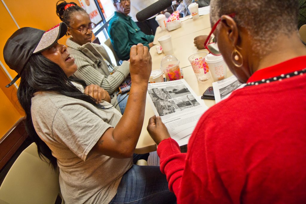 2019 10 16 k paynter refinery report reaction Sonya Sanders, (left), who lives near the Philadelphia Energy Solutions complex in South Philadelphia, reads the Chemical Safety Board's report on the refinery fire. (Kimberly Paynter/WHYY)