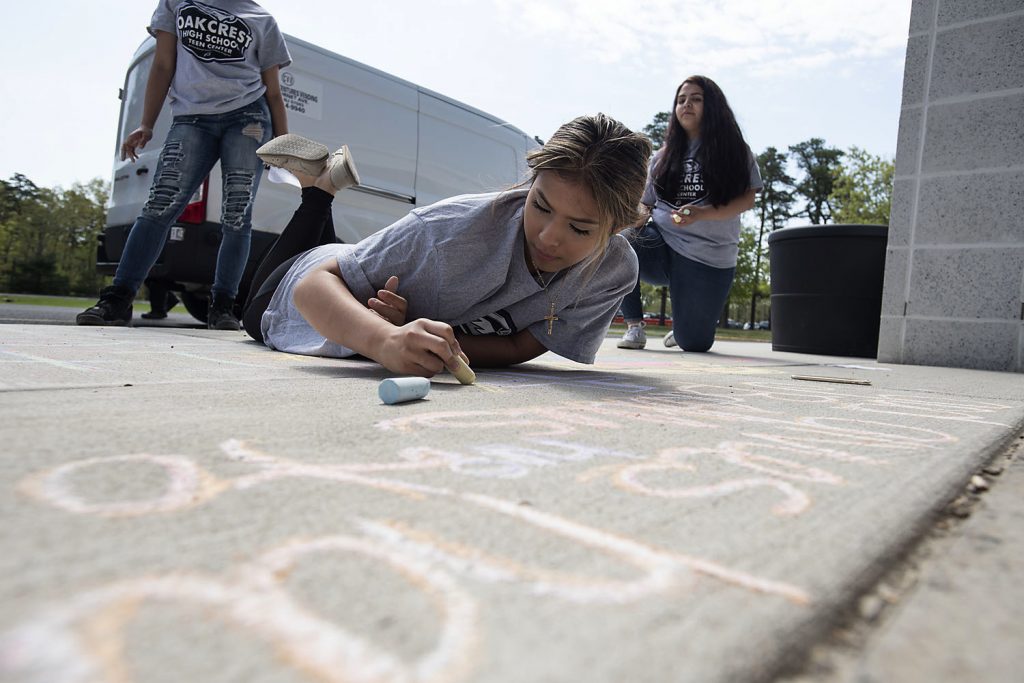 Mental Health Awareness Day Sophomore Fatima Saldana, 16, works on her message as National Children's Mental Health Awareness Day is celebrated with students participating in Messages of Hope, which had them writing positive messages in chalk by the school entrance Thursday, May 10, 2018, at Oakcrest High School in Mays Landing, N.J. (Matthew Strabuk/The Press of Atlantic City via AP)
