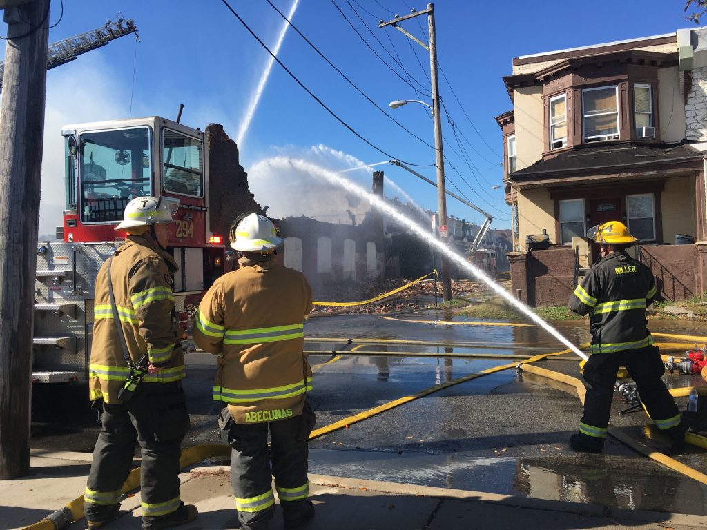 IMG_8258 Firefighters attacking the flames of a fire in an auto shop at 59th and Irving streets in West Philly. (Kimberly Paynter/WHYY)