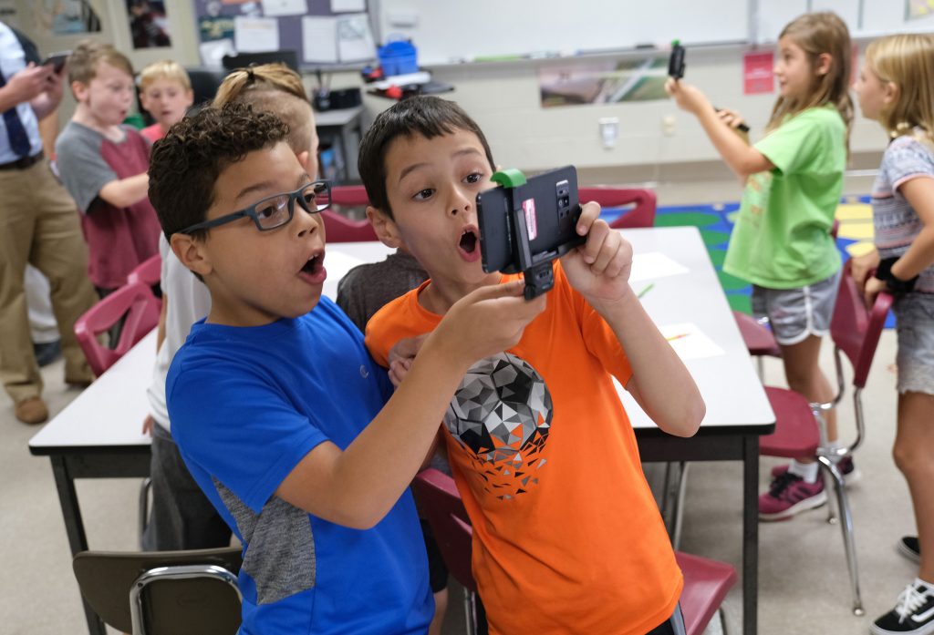 PA-STEM-Grants-in-Berks-County-11-rs Dante Guzman, left, 8, and Emre Tokuc, right, 8, work with a tornado simulation augmented reality program on a smartphone Sept. 26, 2019, at Whitfield Elementary School in Spring Township, Pennsylvania. (Matt Smith for Keystone Crossroads)