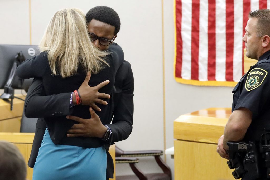 APTOPIX Dallas Officer Mistaken Apartment Botham Jean's younger brother Brandt Jean hugs convicted murderer and former Dallas Police Officer Amber Guyger after delivering his impact statement to her after she was sentenced to 10 years in jail, Wednesday, Oct. 2, 2019, in Dallas. Guyger shot and killed Botham Jean, an unarmed 26-year-old neighbor in his own apartment last year. She told police she thought his apartment was her own and that he was an intruder. (Tom Fox/The Dallas Morning News via AP, Pool)
