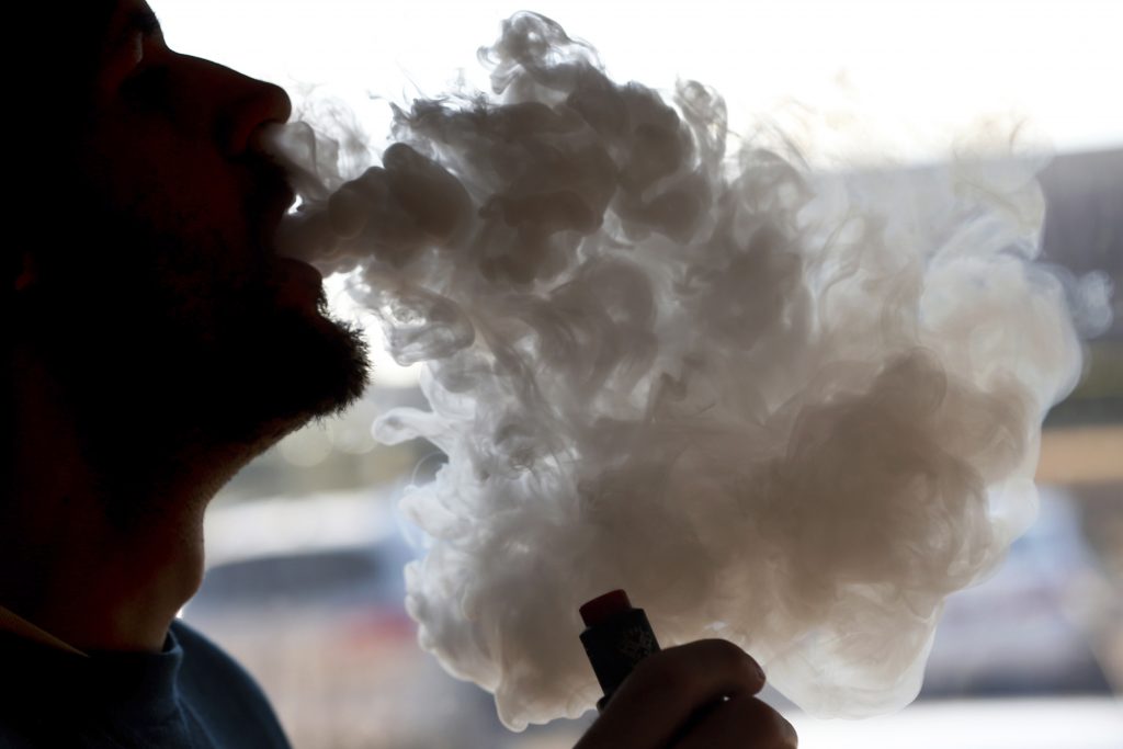 Vaping Illness Congress A man exhales a puff of smoke from a vape pipe