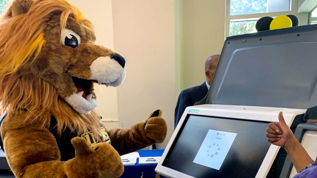 CCP's new mascot, Roary the Lion, learns how to use Philly's new touchscreen voting machines (Twitter/@CCPedu)