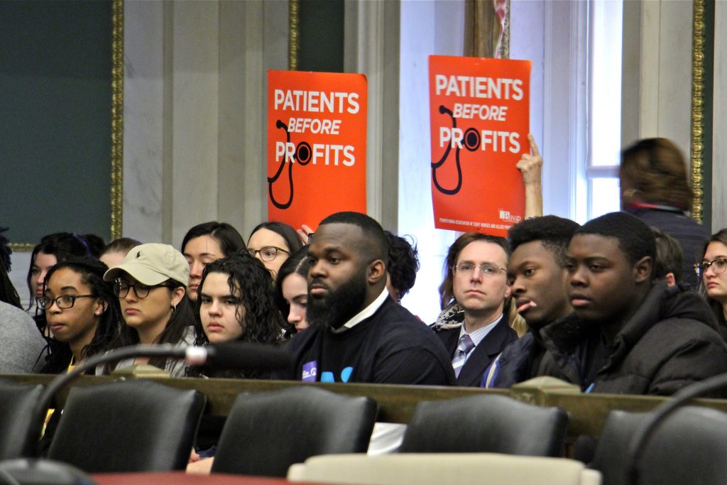2019 11 20-e lee-philadelphia city hall-hospital closure bill Supporters of a bill that woulf require hospitals to submit a closure plan before shutting down hold up signs during a hearing at City Hall. (Emma Lee/WHYY)